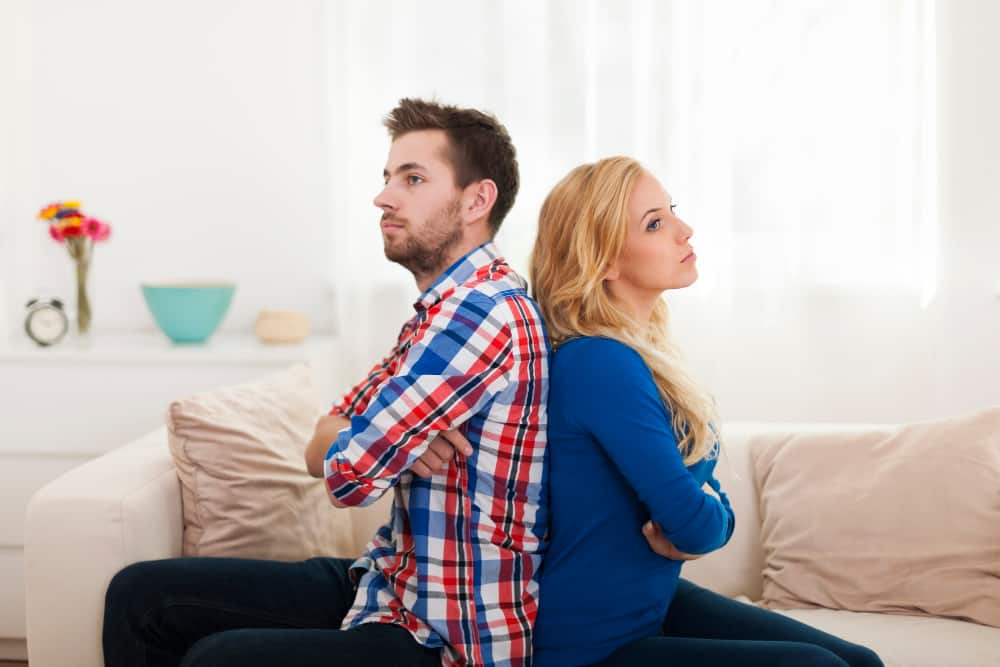 angry-young-couple-sitting-back-back-home